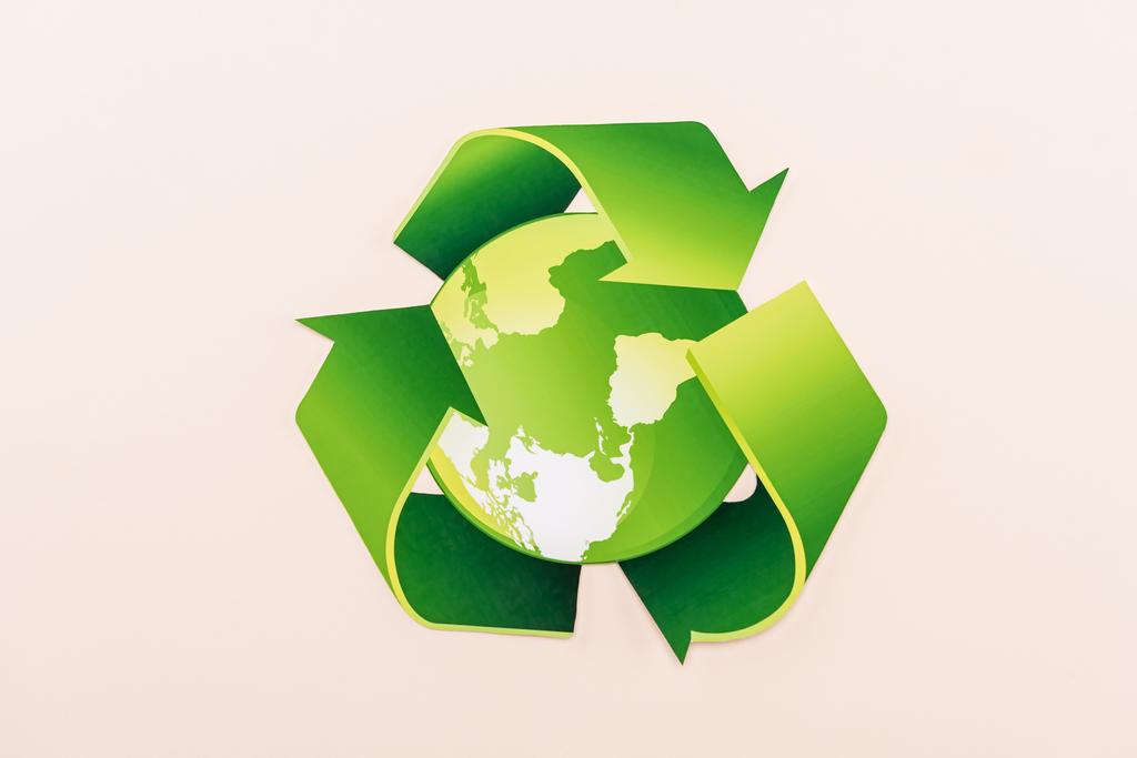 πάνω όψη του πράσινου συμβόλου ανακύκλωσης με τον πλανήτη απομονωμένο σε μπεζ - Φωτογραφία, εικόνα