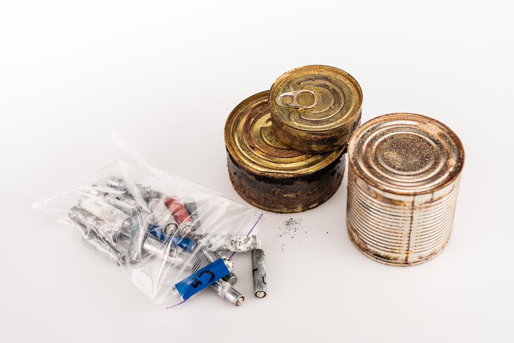 latas oxidadas de metal y baterías usadas sobre fondo blanco - Foto, Imagen