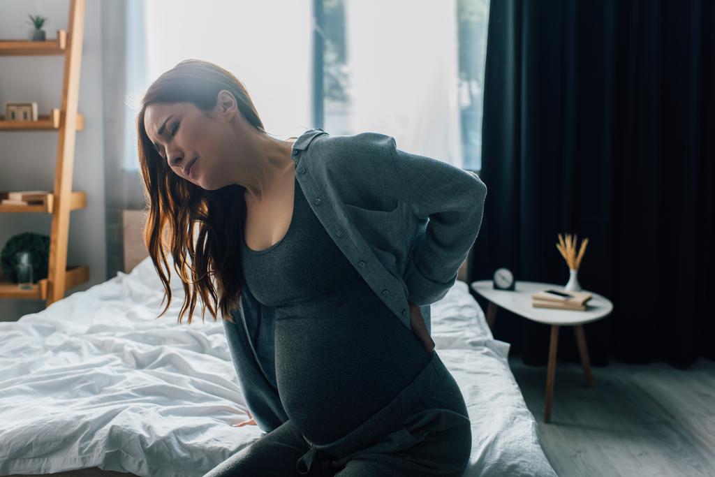 вагітна жінка болить спина в спальні
  - Фото, зображення