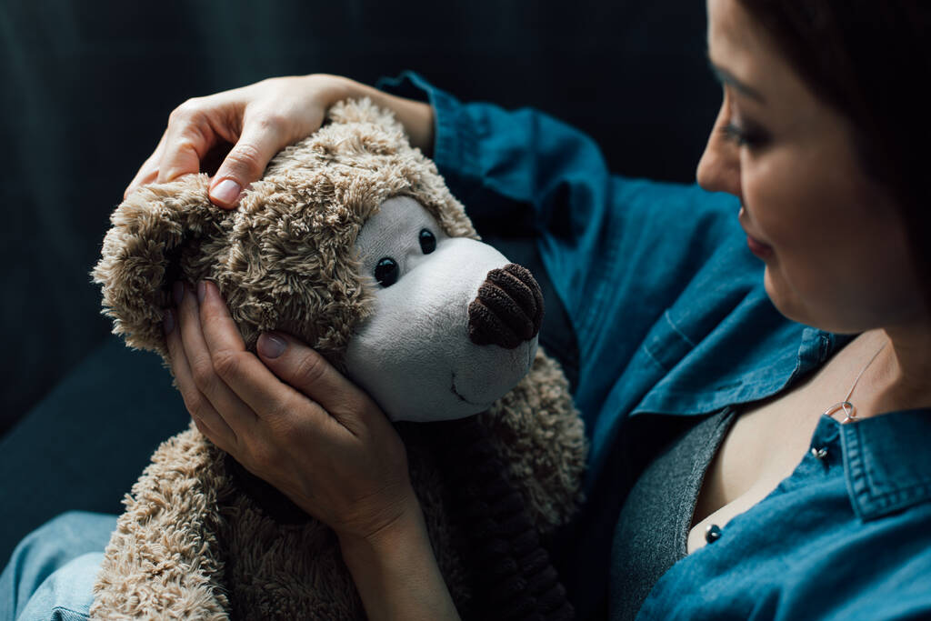 επιλεκτική εστίαση της καταθλιπτικής γυναίκας εκμετάλλευση αρκουδάκι  - Φωτογραφία, εικόνα