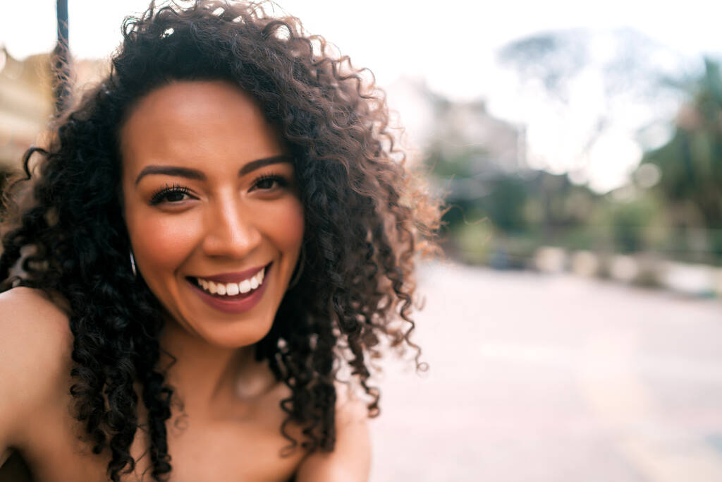 Retrato de uma jovem afro-americana a tirar uma selfie ao ar livre na rua. A desfrutar da vida. Conceito de estilo de vida. - Foto, Imagem