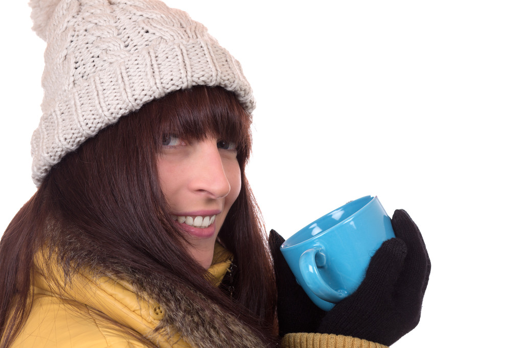 Mujer sonriente bebiendo una taza de té caliente en invierno
 - Foto, imagen