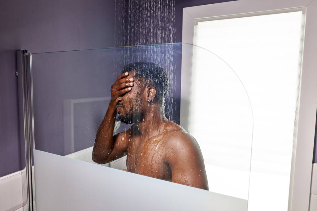 bel homme à la peau foncée prenant une douche dans la salle de bain - Photo, image