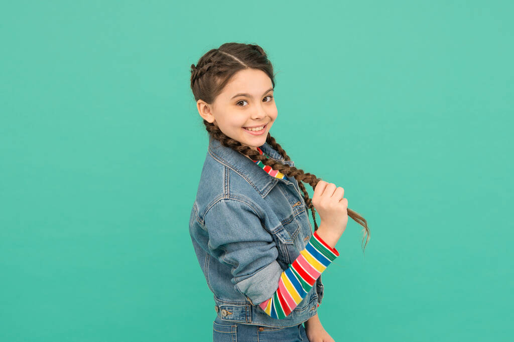Long hair can be fun and playful. Happy girl in pigtails blue background. Little child hold long plait. Trendy hairstyles. Long hair growth stimulants. Hair extensions. Salon haircare - Photo, Image