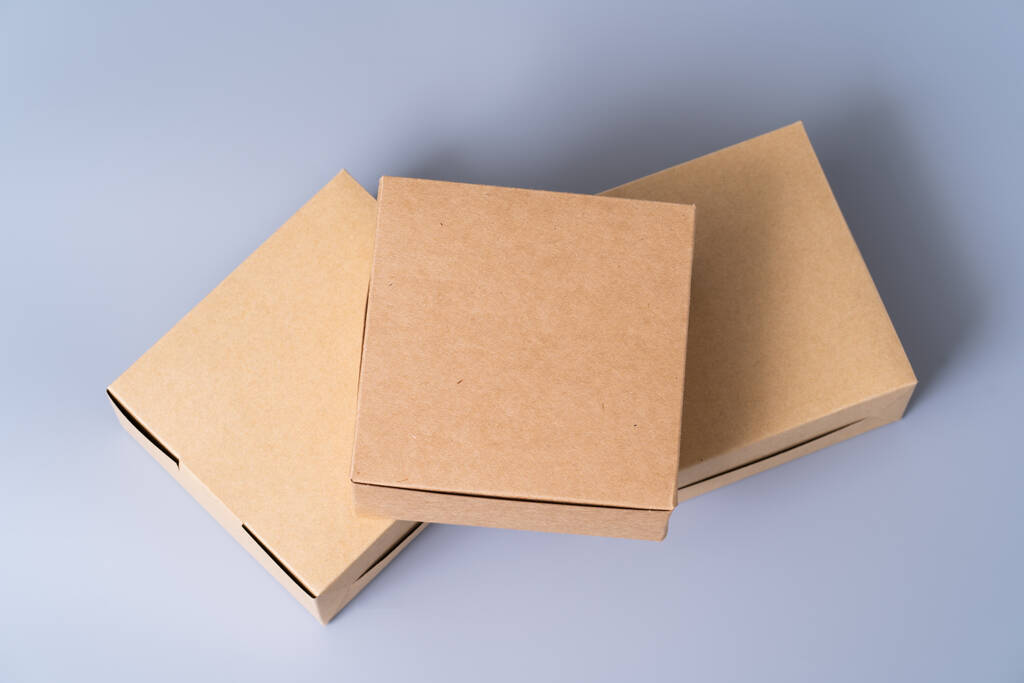 Braune Papierschachtel für Lebensmittelverpackungen. Karton auf grauem Hintergrund. - Foto, Bild
