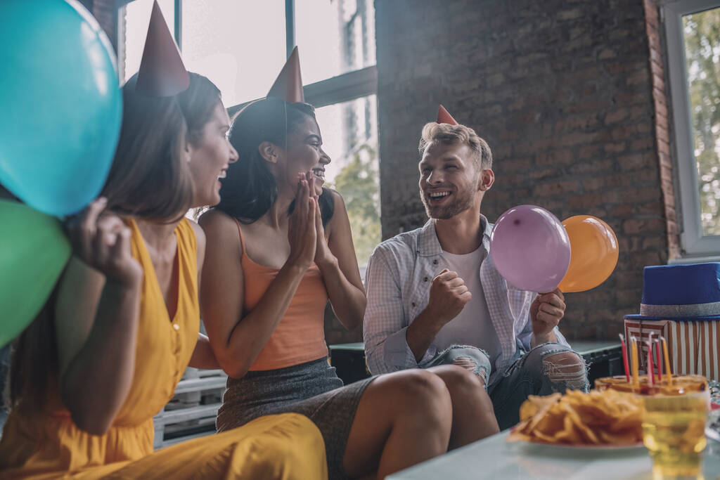 Szczęśliwi przyjaciele śmieją się podczas przyjęcia urodzinowego - Zdjęcie, obraz