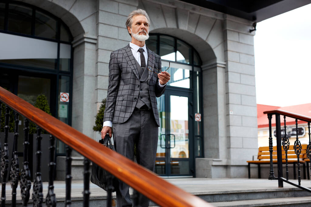 бородатый успешный предприниматель покидает здание после встречи - Фото, изображение