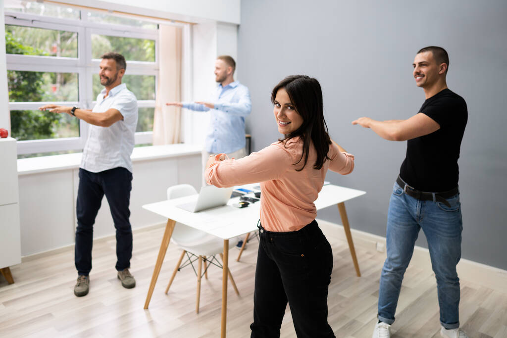Gruppe von glücklichen jungen Geschäftsleuten macht Stretching-Übung im Büro - Foto, Bild