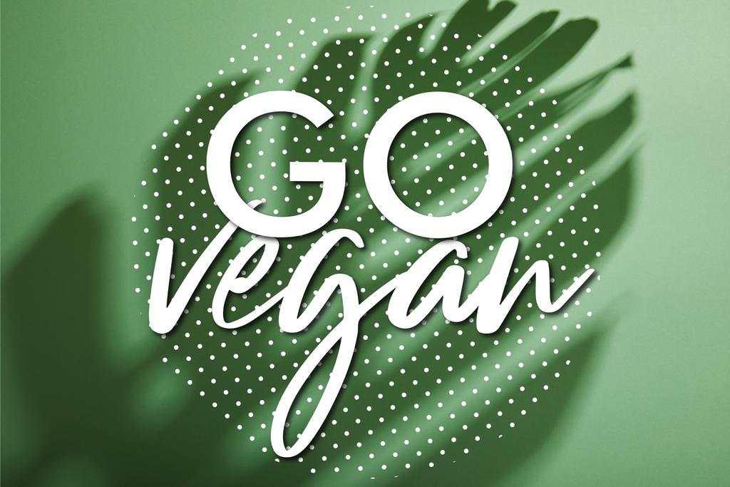 tropical leaf shadow on green background with go vegan illustration - Photo, Image