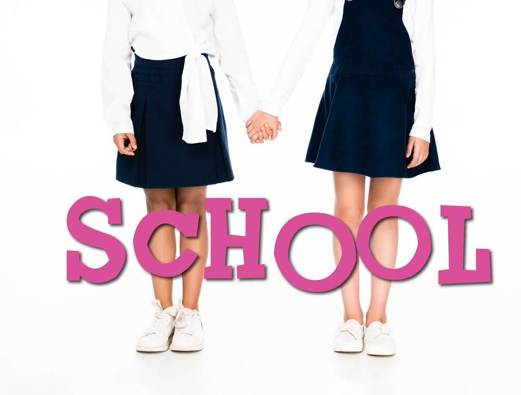 abgeschnittene Ansicht von multikulturellen Schulmädchen, die Hände auf weißem Hintergrund halten, Schulillustration - Foto, Bild