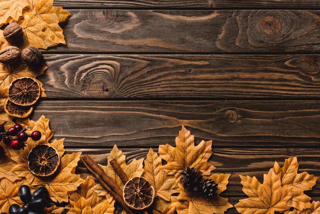 верхний вид осеннего декора и листвы на коричневом деревянном фоне - Фото, изображение
