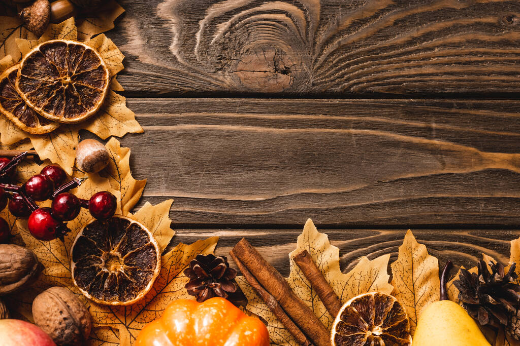 bovenaanzicht van herfstoogst en decoratie op bruine houten ondergrond - Foto, afbeelding