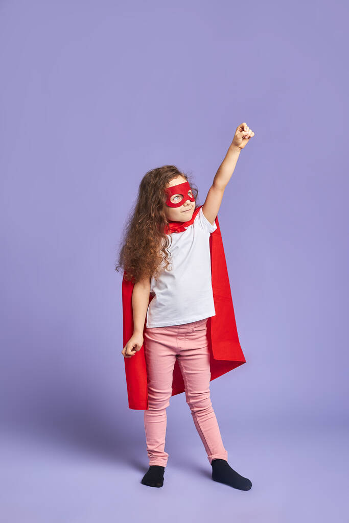 赤いスーツとマスクを身に着けている子供はスーパーヒーローとして自分自身を想像する - 写真・画像