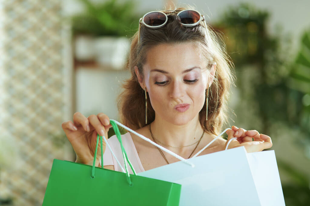 dubitare donna moderna shopper in occhiali da sole con sacchetti di carta shopping. - Foto, immagini