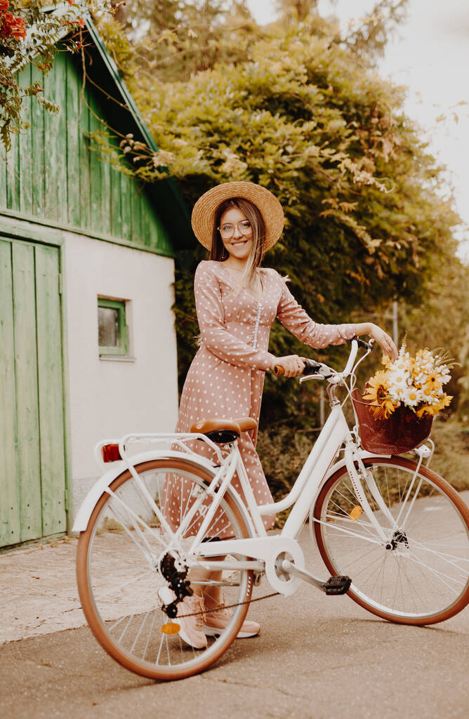 Giovane donna con bicicletta in campagna - Foto, immagini