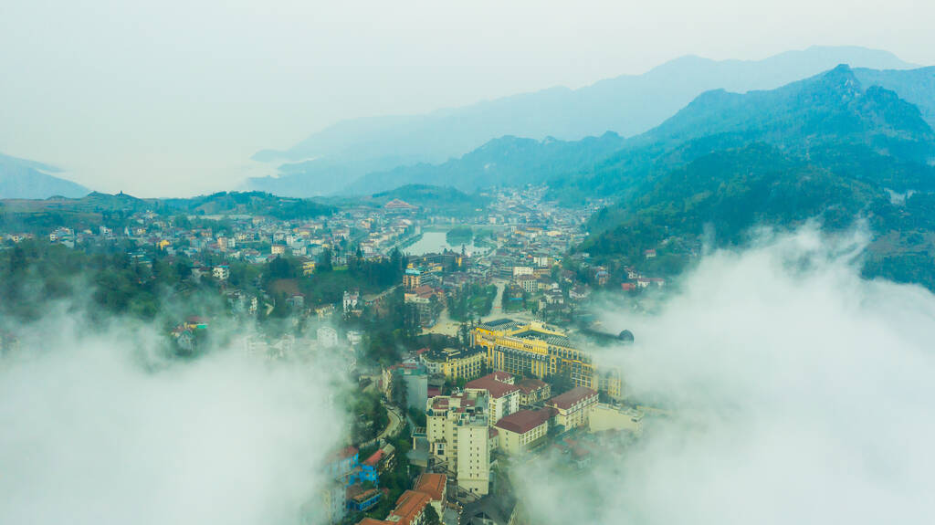 Вид с воздуха на панорамный пейзаж города Сапа, провинция Лао Цай, Вьетнам в Азии с солнечным светом и закатом, вид на горы в облаках - Фото, изображение