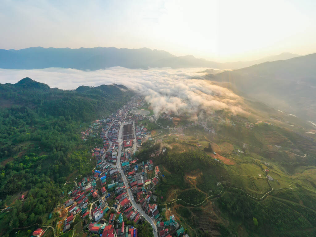 太陽の光と日没、雲の中の山の景色とアジアのサパ市、ラオス蔡州、ベトナムの丘の町でのパノラマ風景の空中ビュー - 写真・画像