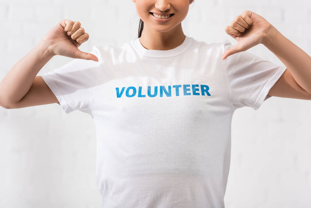 Widok woluntariusza pokazującego koszulkę z literami  - Zdjęcie, obraz