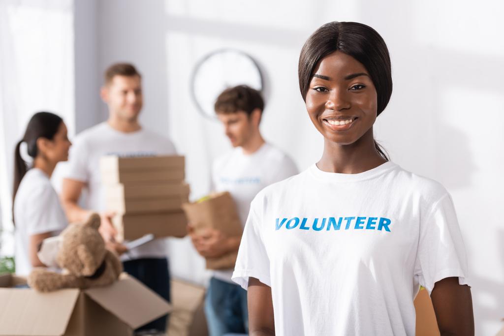 Вибірковий фокус афроамериканського добровольця, який дивиться на камеру в благодійному центрі
  - Фото, зображення