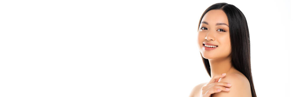 Panoramic shot of asian woman touching shoulders and looking at camera on white background - Photo, Image