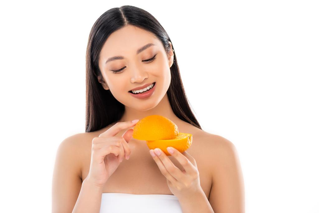 joven asiático mujer celebración mitades de maduro naranja aislado en blanco - Foto, Imagen