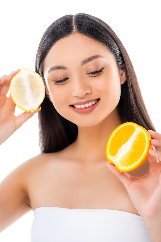 fiatal ázsiai nő gazdaság fél citrom és narancs izolált fehér - Fotó, kép