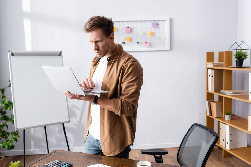 Вибірковий фокус бізнесмена в повсякденному одязі за допомогою ноутбука в офісі
  - Фото, зображення