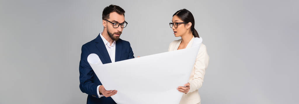 imagen horizontal de pareja interracial de empresarios con pancarta aislada en gris - Foto, Imagen
