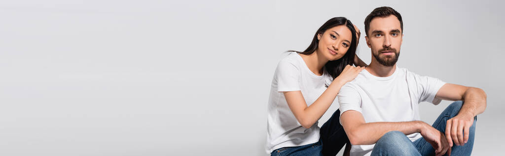 horizontal concept of asian woman leaning on shoulder of boyfriend while sitting on white - Photo, Image