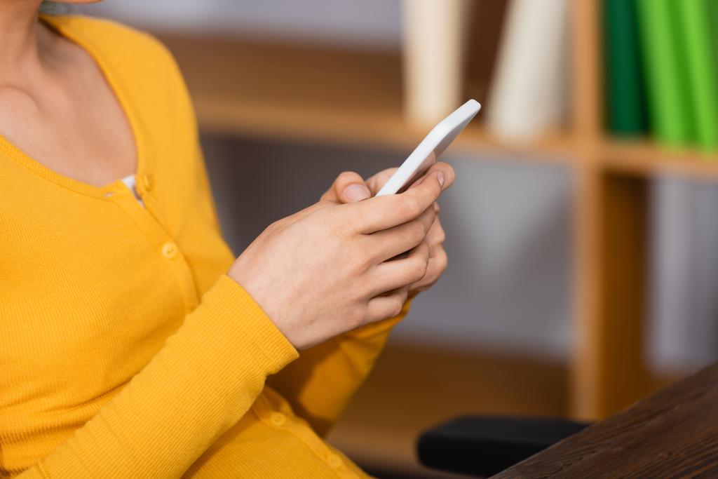 abgeschnittene Ansicht einer jungen Frau, die zu Hause auf dem Smartphone chattet, selektiver Fokus - Foto, Bild