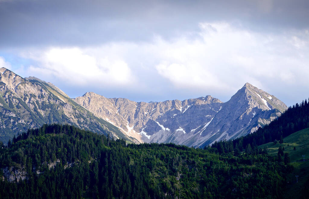 Ένα όμορφο πλάνο του πράσινου οροπεδίου με βραχώδεις κορυφές βουνών στο παρασκήνιο - Φωτογραφία, εικόνα