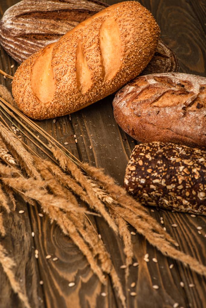 свіжий хлібний хліб з колосками на дерев'яній поверхні
 - Фото, зображення