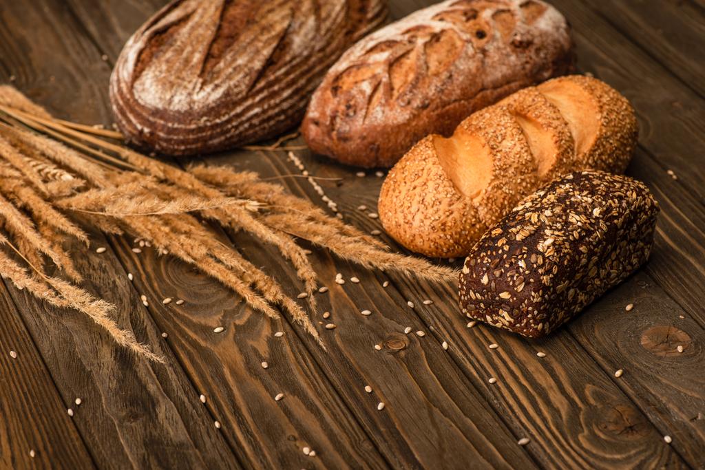 свіжий хлібний хліб з колосками на дерев'яній поверхні
 - Фото, зображення