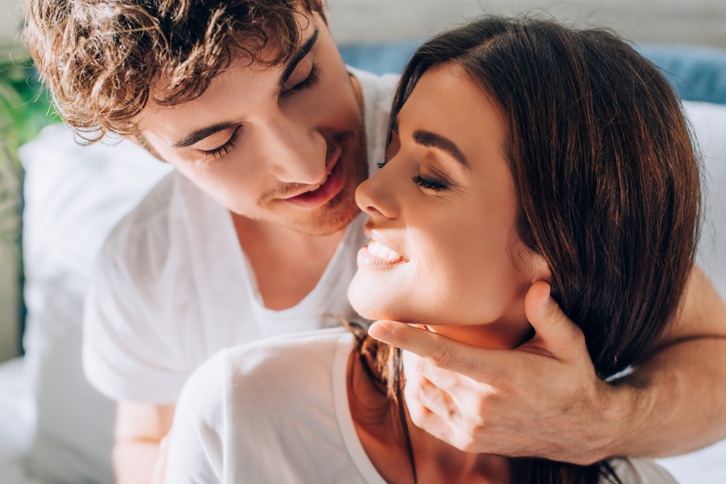 Young man looking at girlfriend and touching neck and face  - Photo, Image
