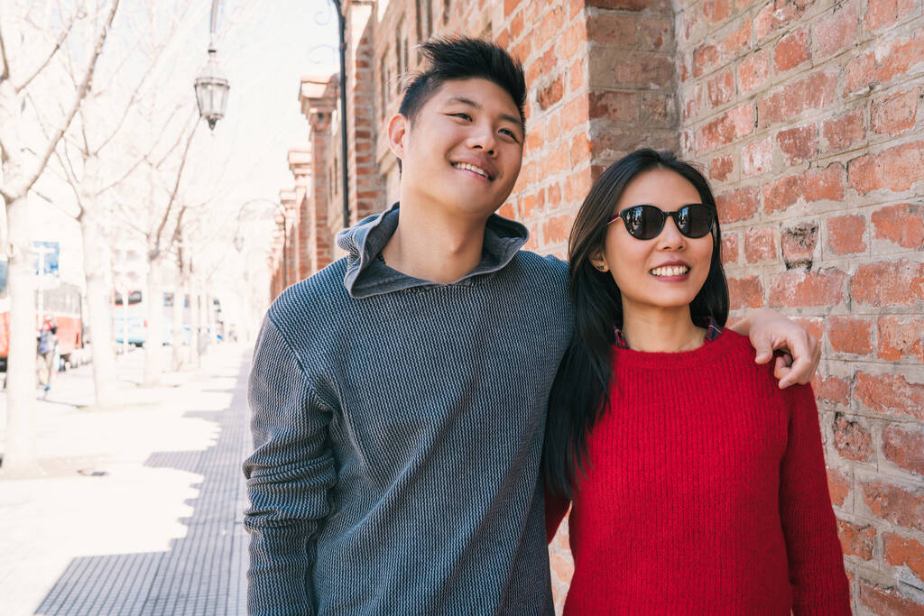 Nuoren aasialaisen parin muotokuva rakastuneena kävelemässä kaupungissa ja pitämässä hauskaa yhdessä. Rakkauden käsite. - Valokuva, kuva