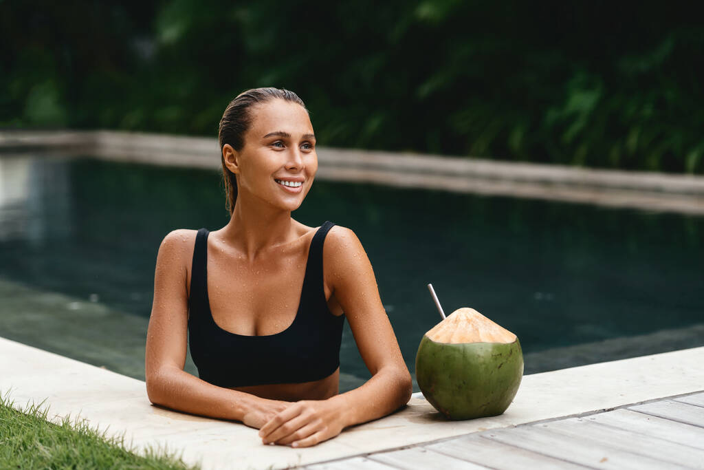 портрет милої дівчини з кокосовим коктейлем в тропічному басейні
. - Фото, зображення