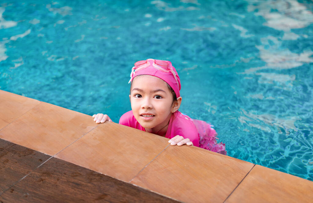 Joven asiática chica en traje de baño oliendo en siwmming piscina, activo verano vacaciones concepto. - Foto, Imagen