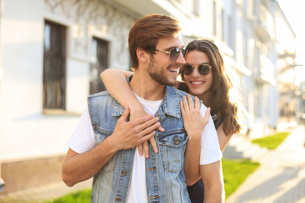 Belo jovem casal apaixonado andando ao ar livre na rua da cidade, abraçando - Foto, Imagem