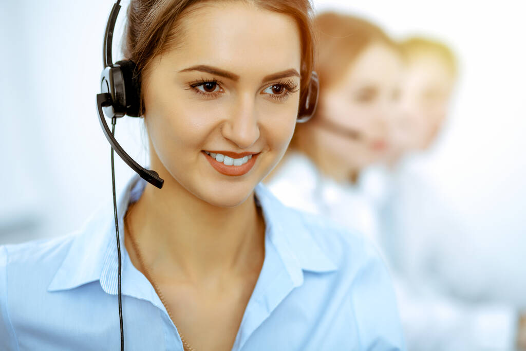 Operadores del centro de llamadas. Enfoque en hermosa mujer de negocios en auriculares. - Foto, Imagen