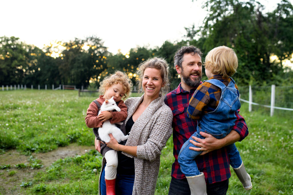 Портрет сім'ї з маленькими дітьми, що стоять на фермі, відпочивають
. - Фото, зображення