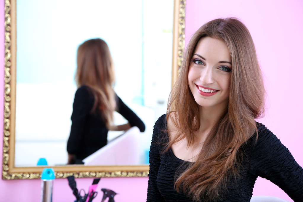 Nuori kaunis nainen istuu edessä peili huoneessa
 - Valokuva, kuva