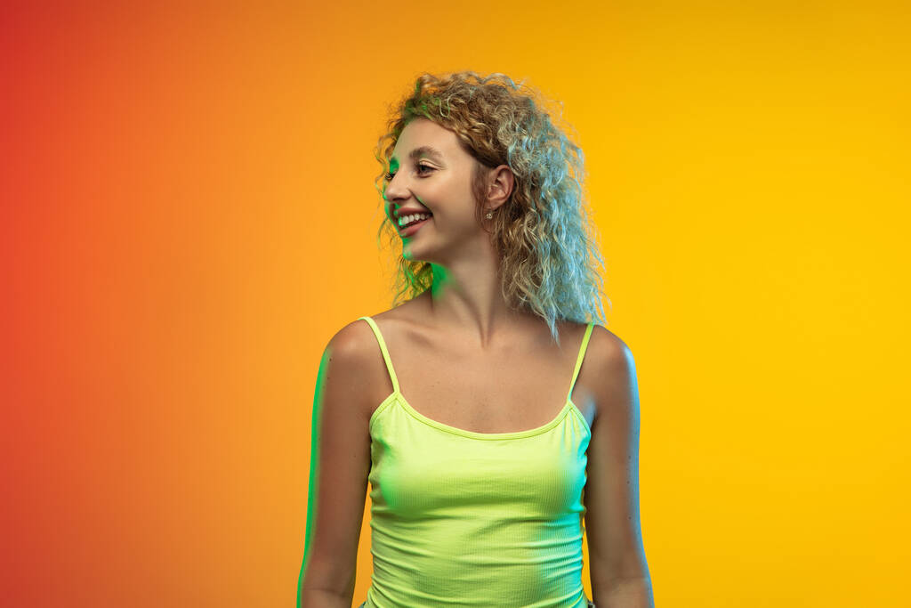 Caucasian young womans portrait on gradient studio background in neon - Photo, Image