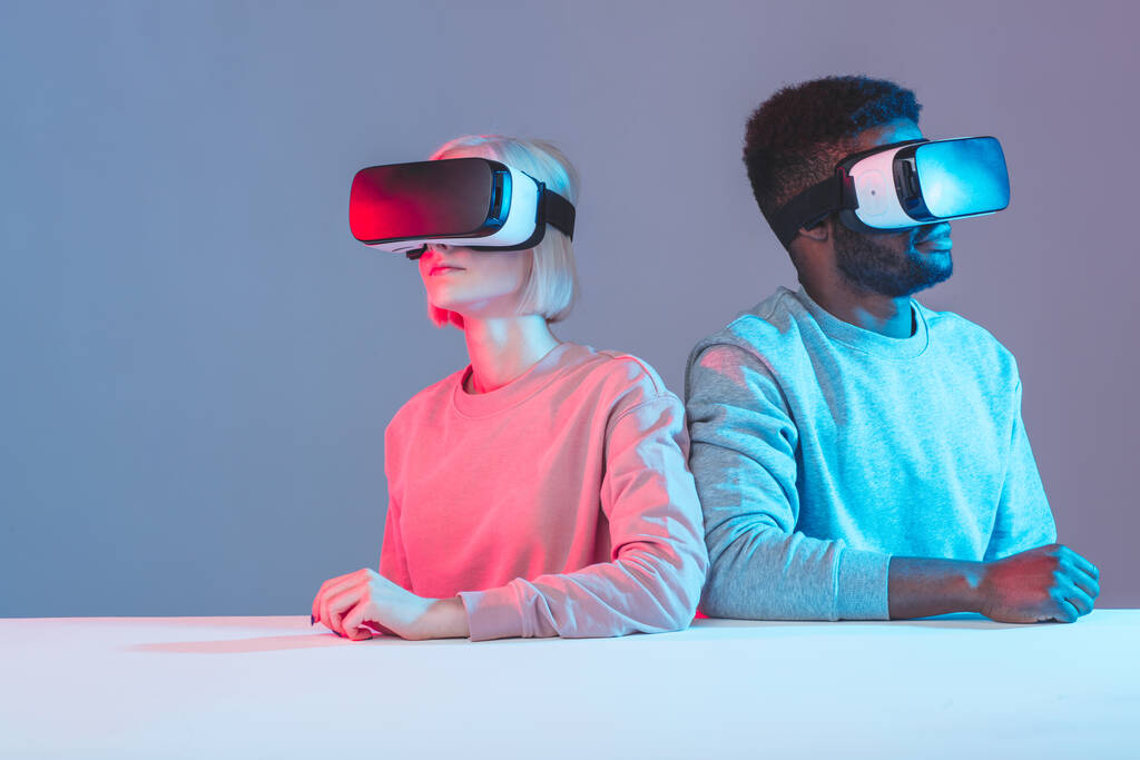 kansainväliset nuoret istuvat pöydässä ja käyttävät VR:n suojalaseja - Valokuva, kuva