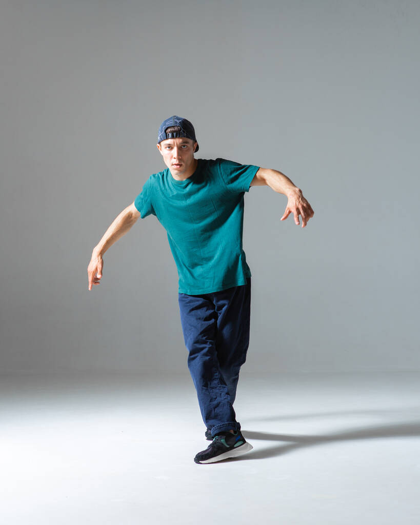 Guay chico breakdancer bailando en estudio aislado sobre fondo gris. Clases de Breakdance - Foto, Imagen