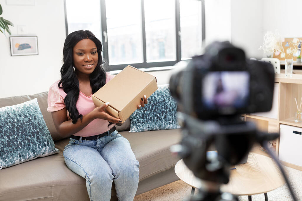 video blogger femenina con cámara y caja en casa - Foto, Imagen