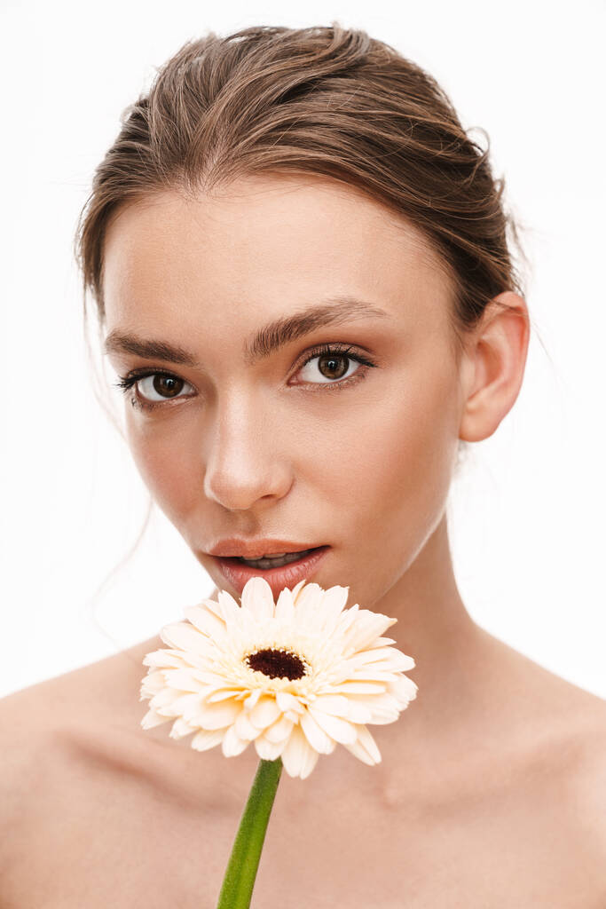 美しいcucasian若いです幸せな白い背景の上に隔離されたガーバーの花を保持する白人の女性 - 写真・画像