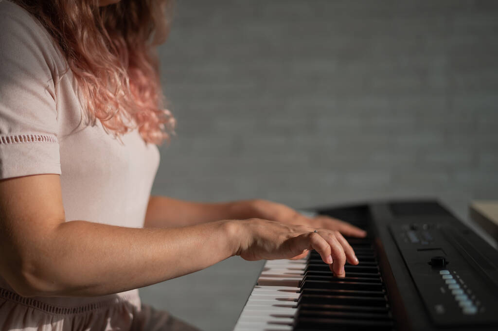 Primo piano delle mani femminili sul pianoforte elettrico. Donna musicista suona uno strumento a tastiera. - Foto, immagini