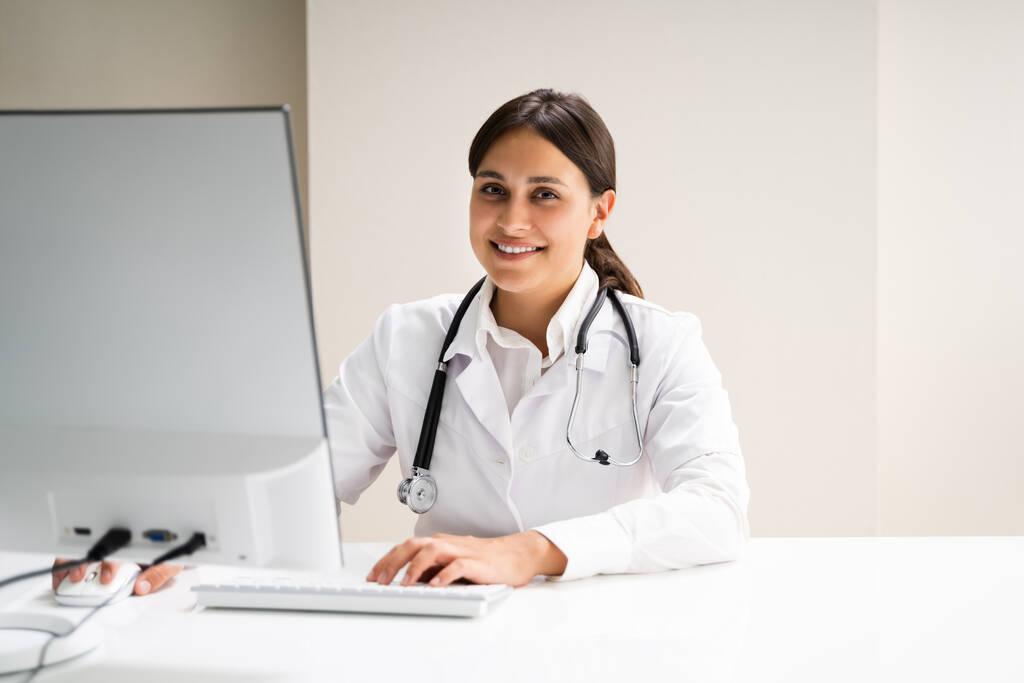 Feliz médico médico mujer en escritorio de la computadora - Foto, imagen
