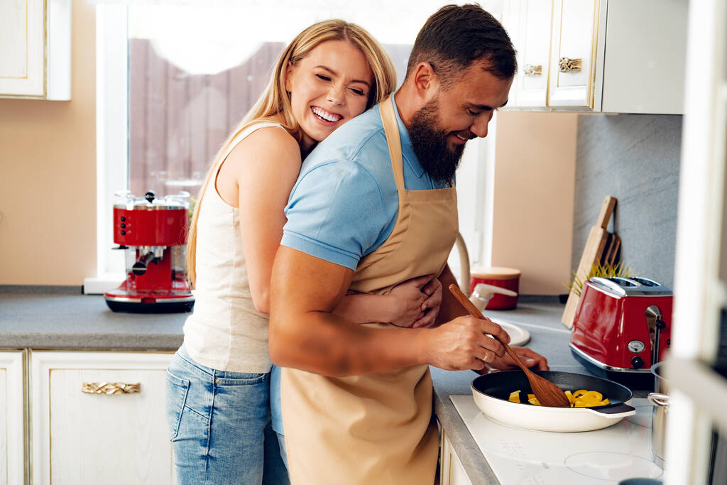 Verliebtes Paar bereitet gemeinsam Mahlzeit in Küche zu - Foto, Bild