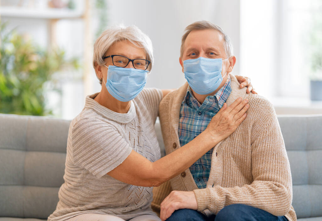 Ηλικιωμένο ζευγάρι που φορούσε μάσκες προσώπου κατά τη διάρκεια του ιού της στέψης και της γρίπης. Προστασία ιών και ασθενειών, καραντίνα στο σπίτι. COVID-2019. Φορώντας ή βγάζοντας μάσκες. - Φωτογραφία, εικόνα